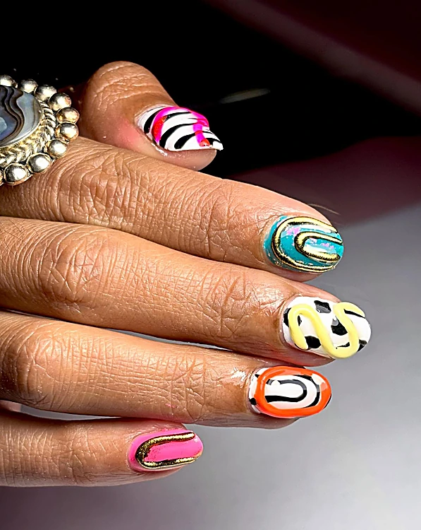 Uñas cortas con diseño abstracto: cebra rosa, turquesa con dorado, manchas amarillas y naranja