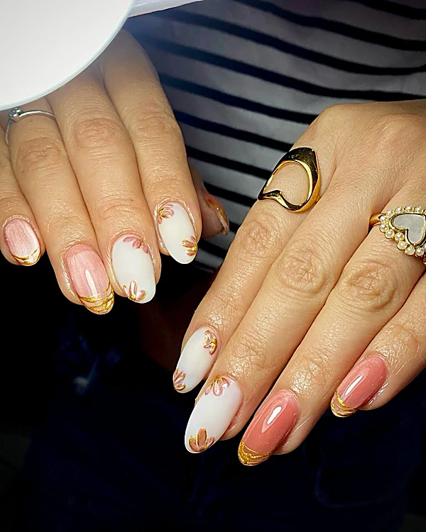 Uñas almendra blancas y durazno con hojas doradas pintadas a mano